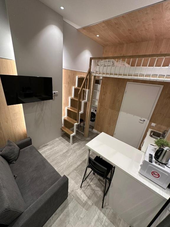 Tilžės Studio Apartments - split level studio with loft bed and sofa